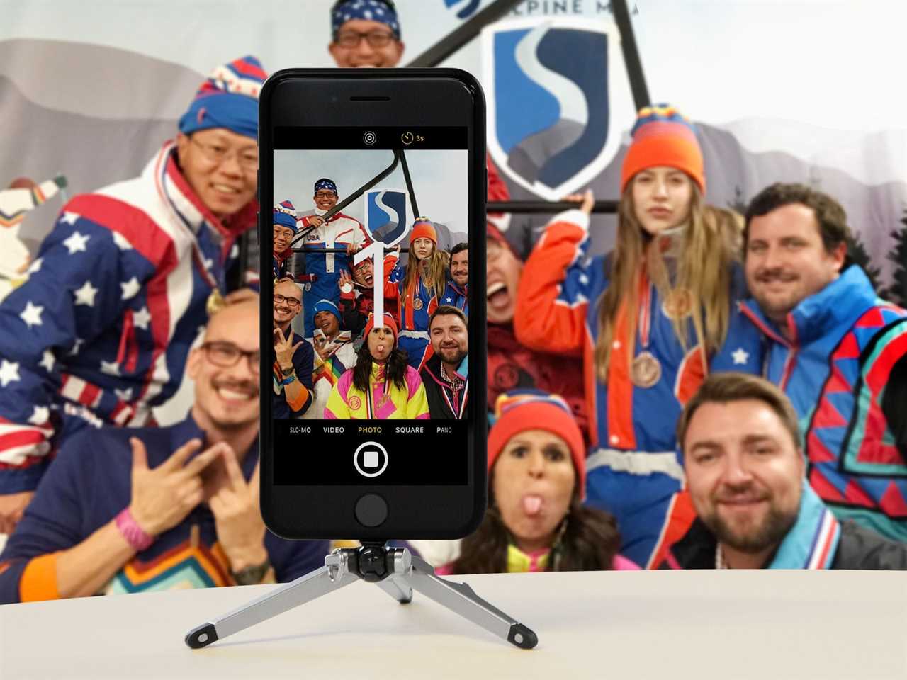 A lifestyle image of the Kenu Stance smartphone tripod and iPhone being used for a group photo.