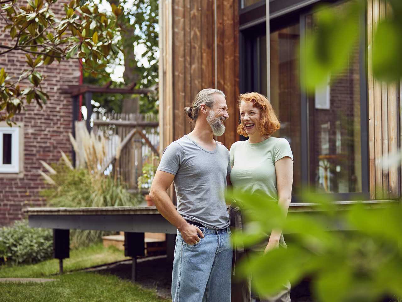 A couple in front of their new home.