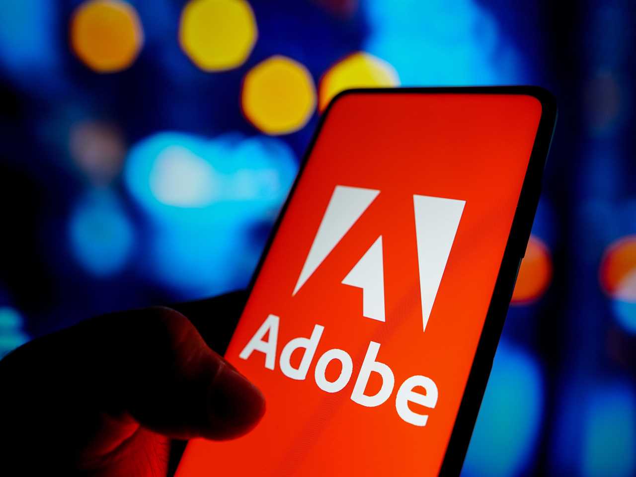 In this photo illustration, the Adobe Inc. logo seen displayed on a smartphone screen.