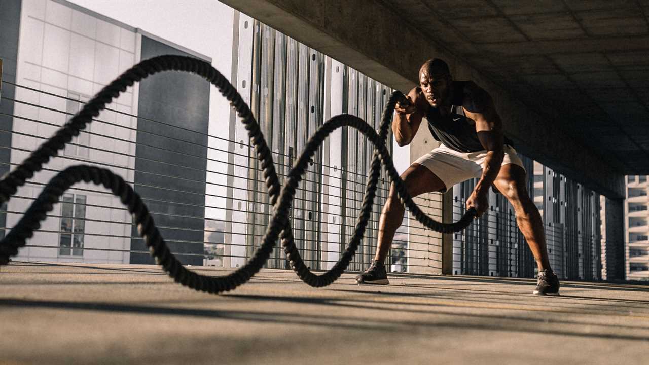 Man working out with battle ropes in a parking garage
