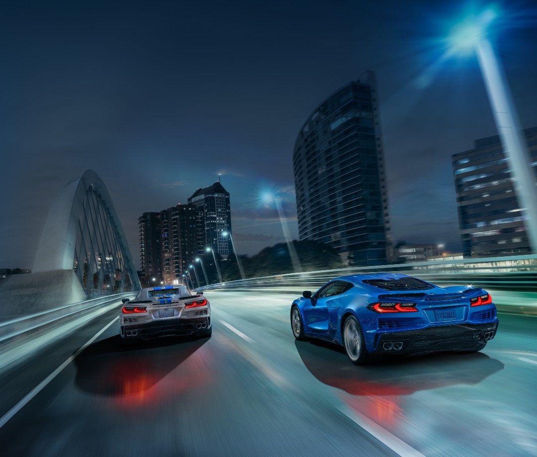 Blue and gray sports cars driving fast on highway