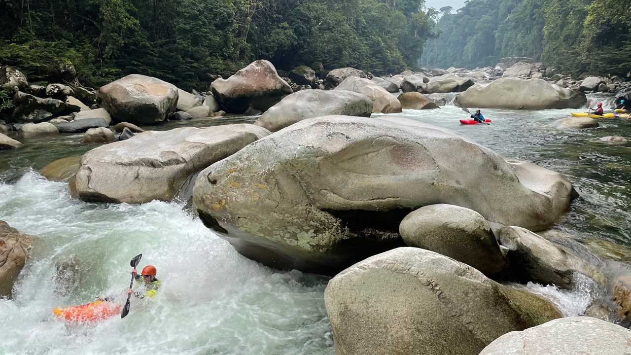 Kayakers paddling down a rocky stretch of river in Ecuador