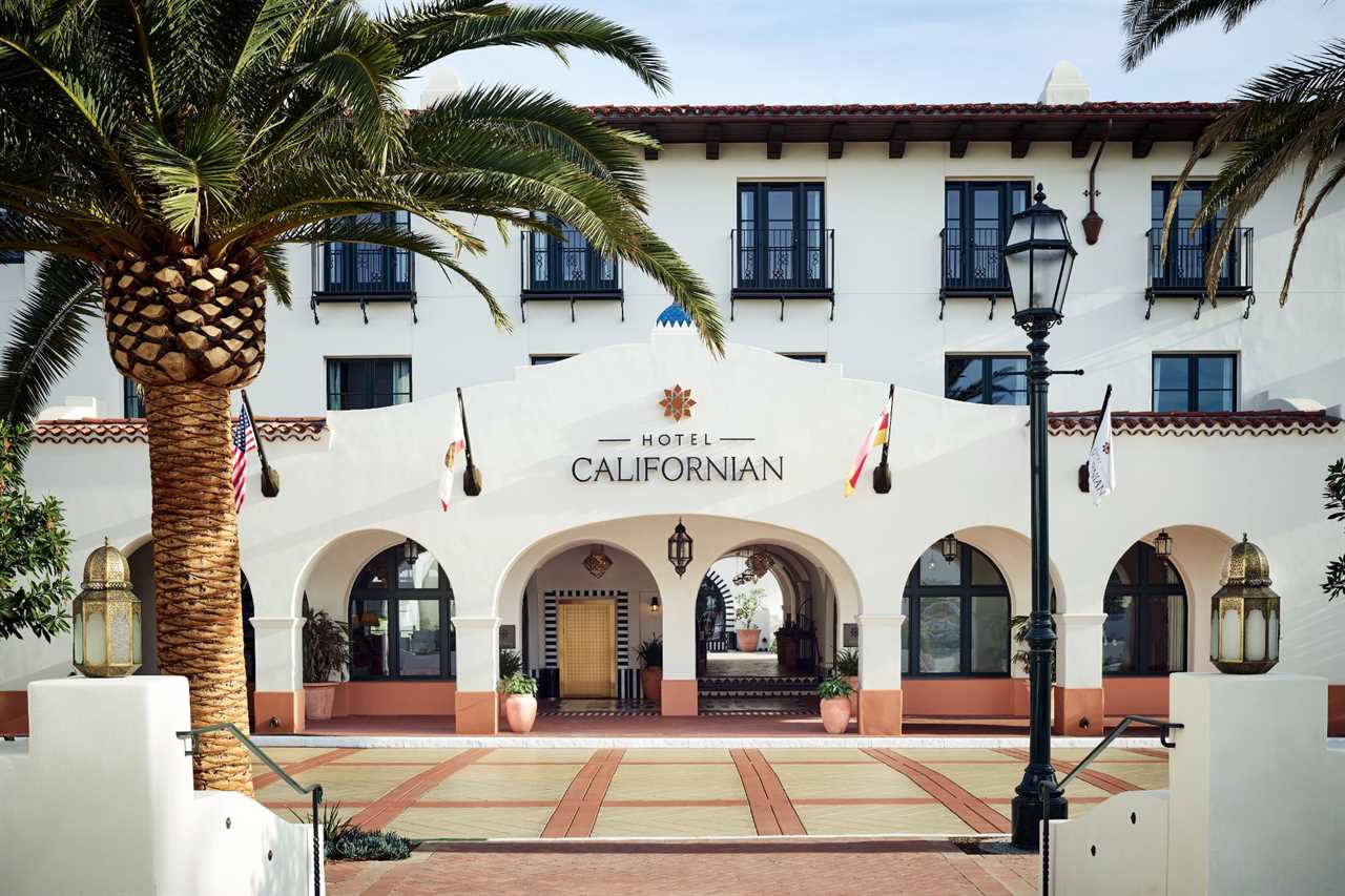 Exterior of Hotel Californian property: Spanish-style white exterior with palm tree