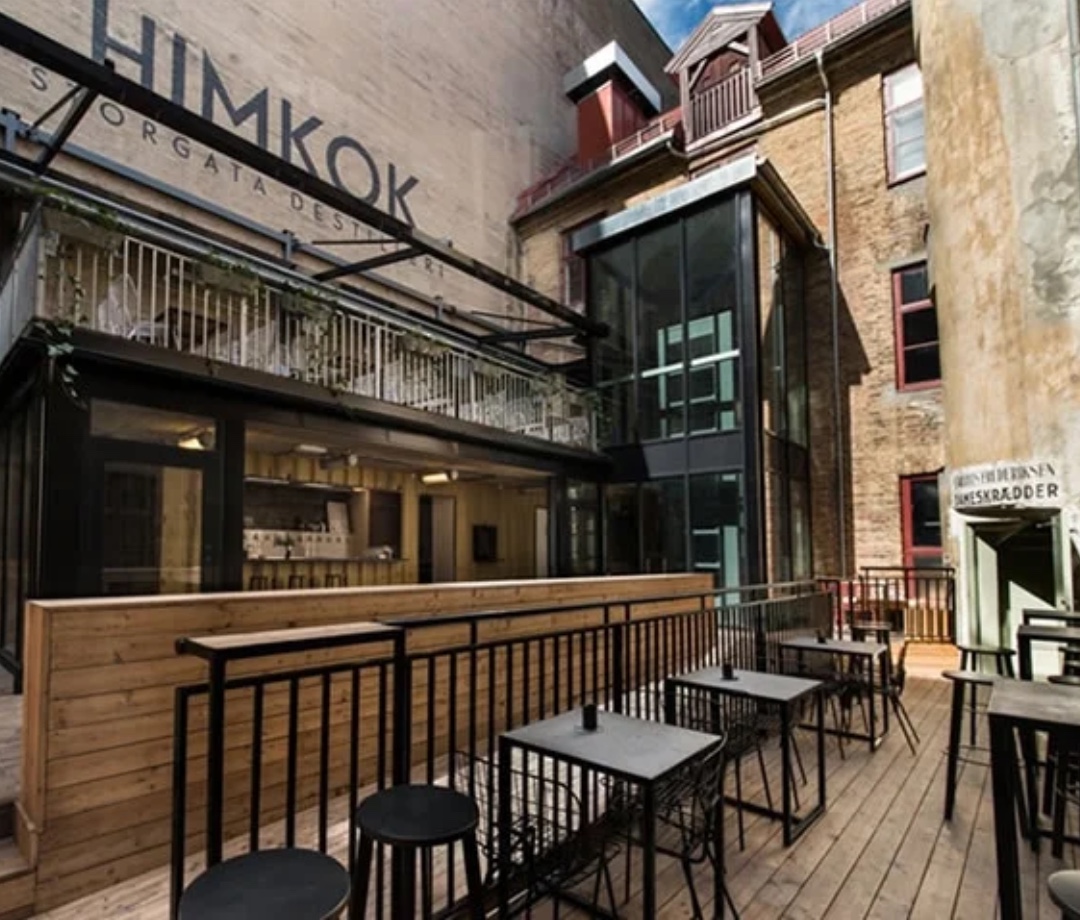 Outside of a bar called Hickok in an old part of town with brick buildings in the background.