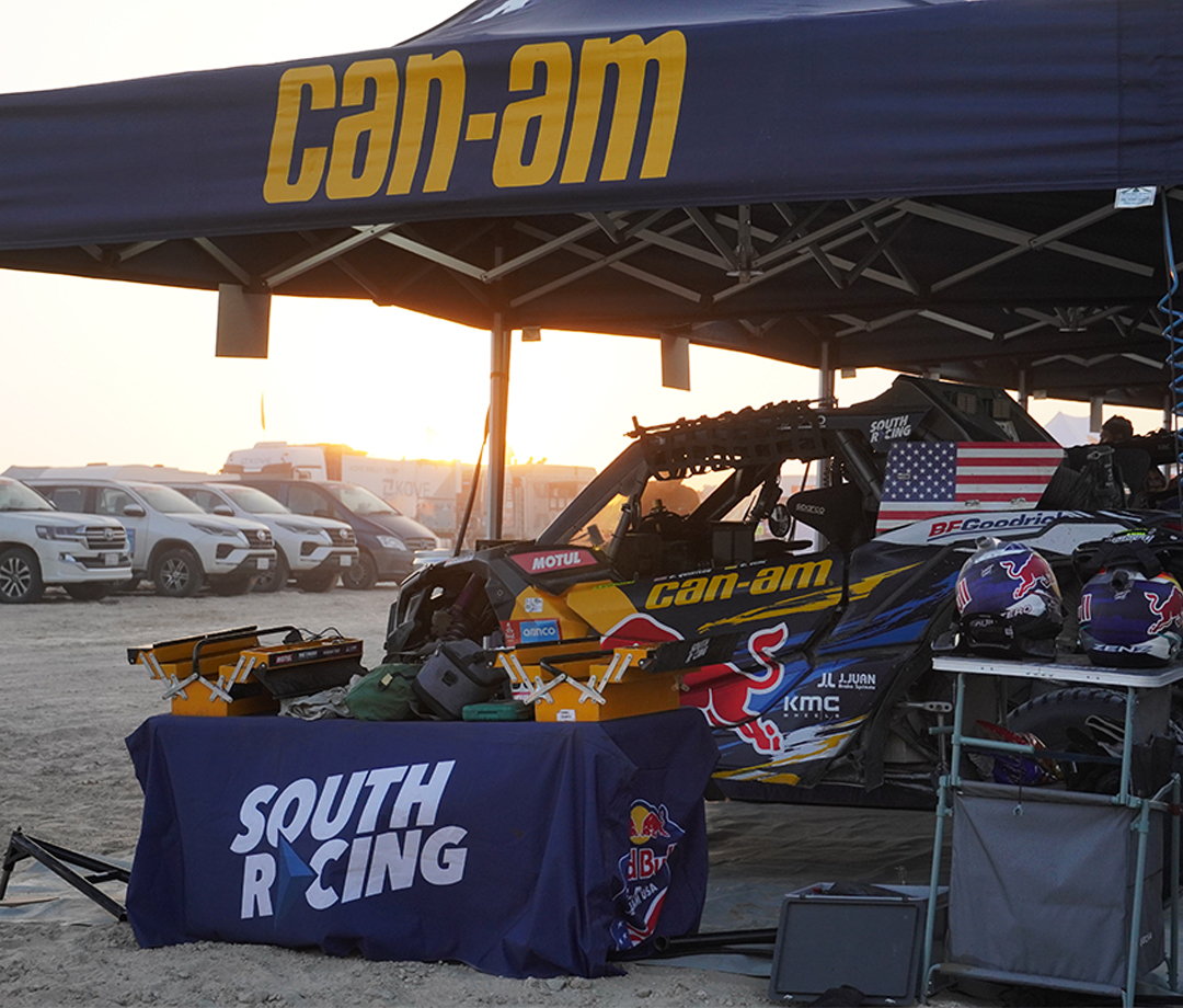 Awning in the desert with a side by side off-roader underneath it as the sun sets.