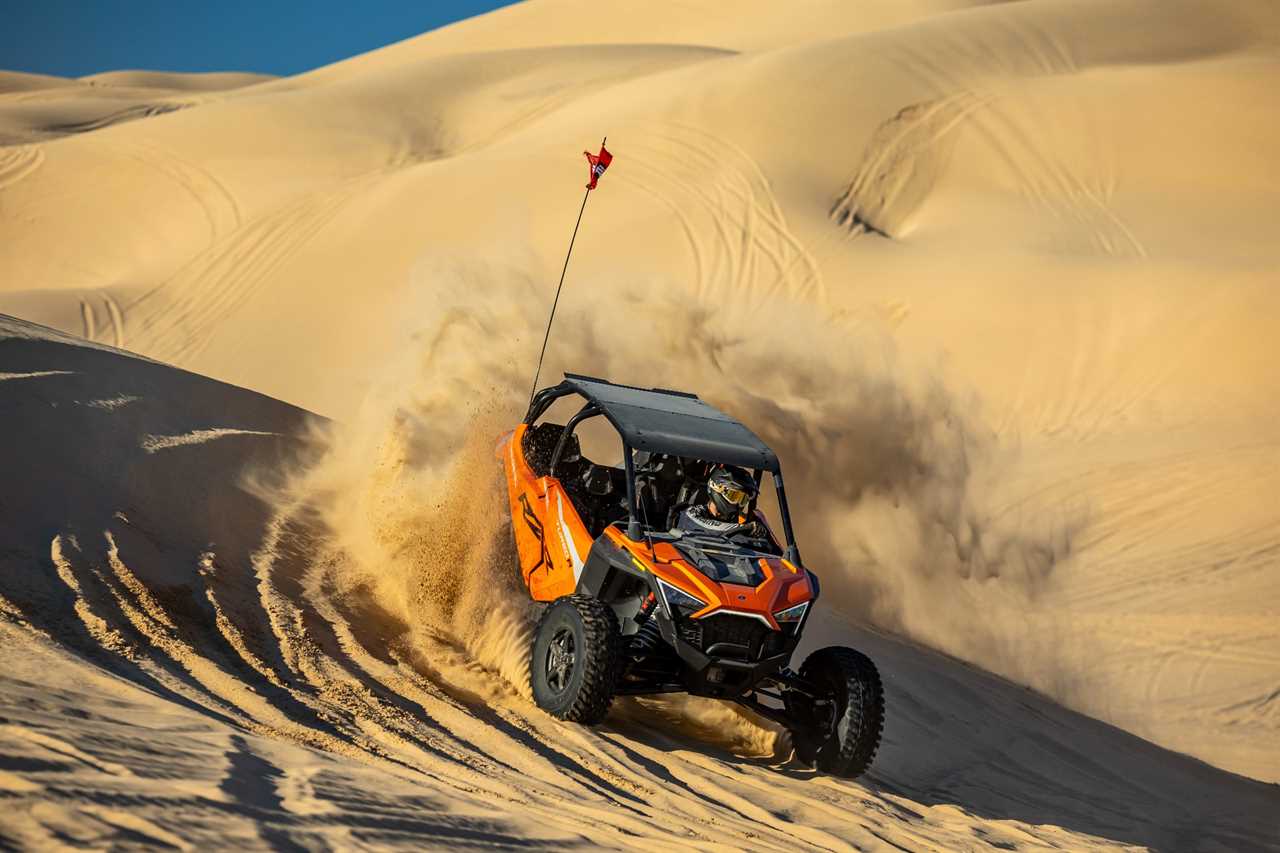 Camp RZR attendant zipping through the dunes in a side-by-side.