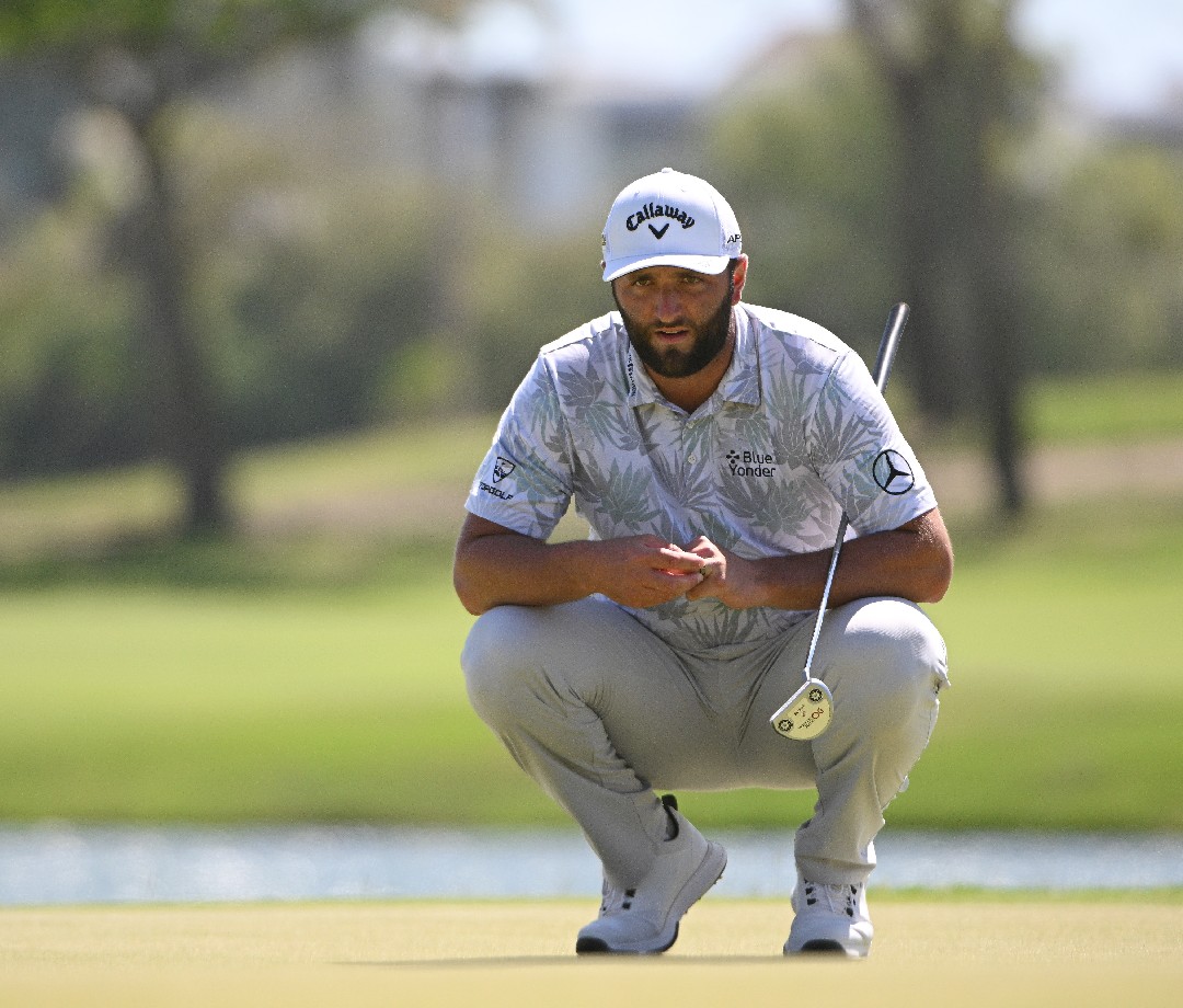 Jon Rahm kneeling before a shot.