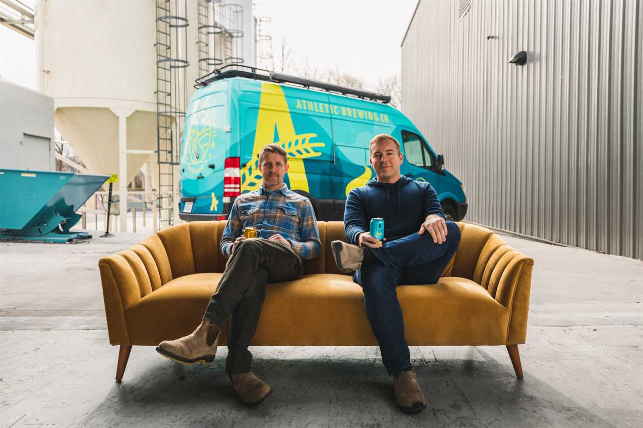 John Walker and Bill Shufelt of Athletic Brewing Co. seated on a sofa