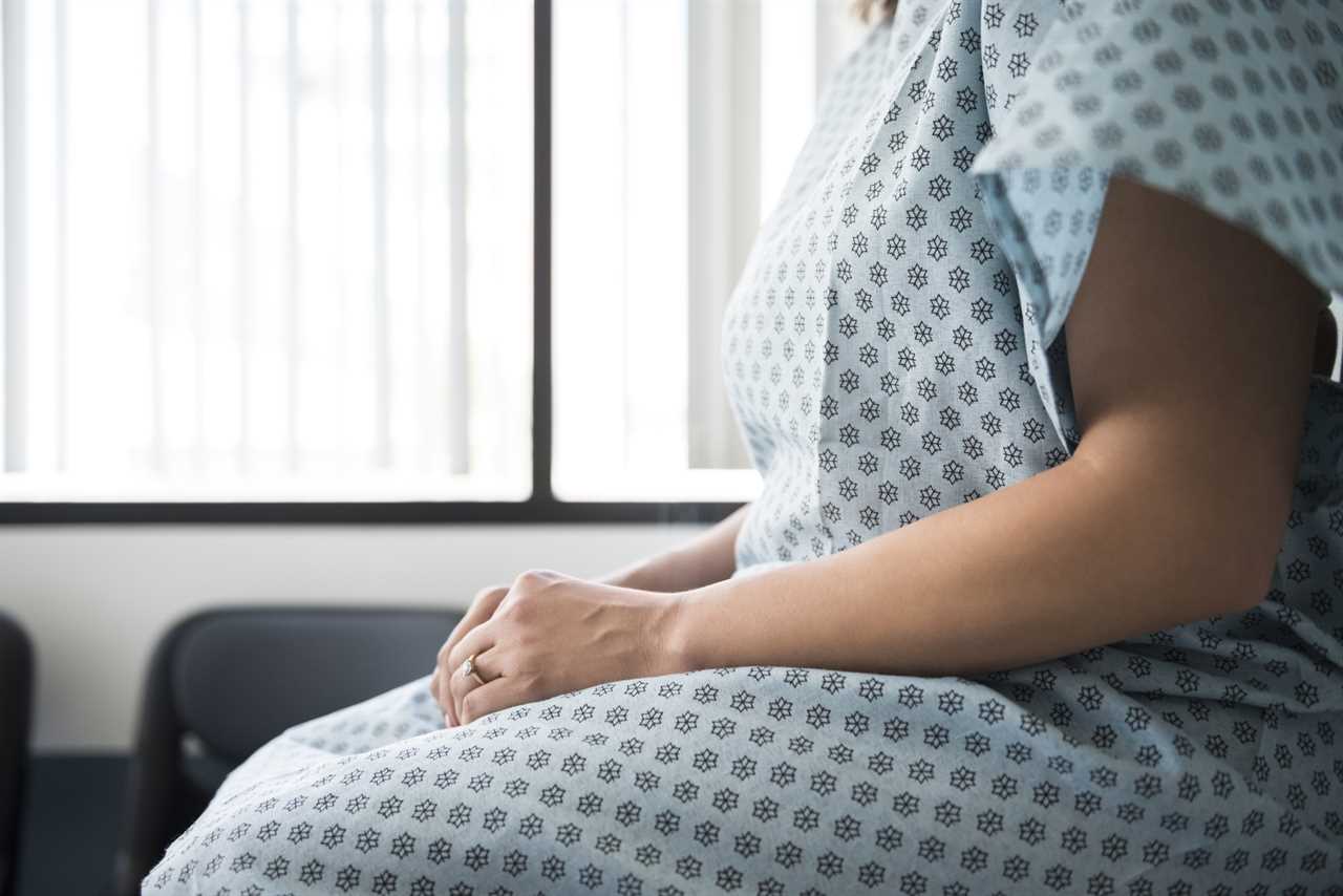 Midsection of female patient waiting in hospital exam room