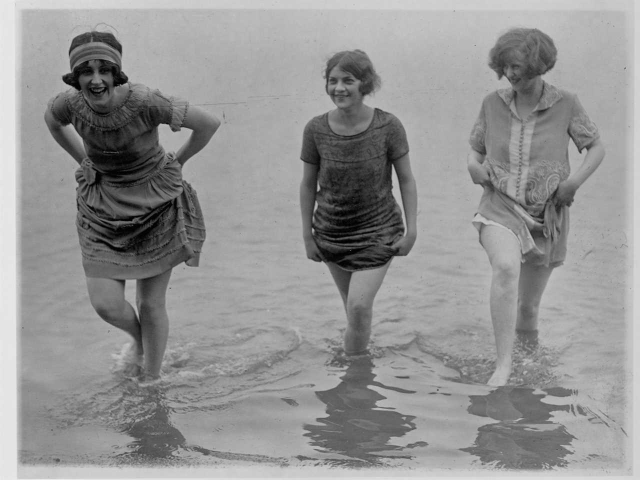 Three models from Washington's spring fashion show raise the hems of their dresses so they can wade through the waters of Arlington Beach in 1924
