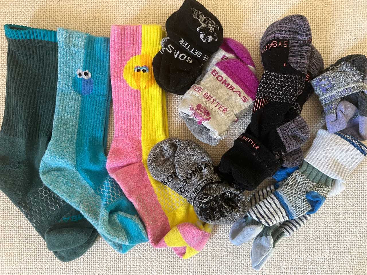 Several styles of Bombas socks laid out on the floor.