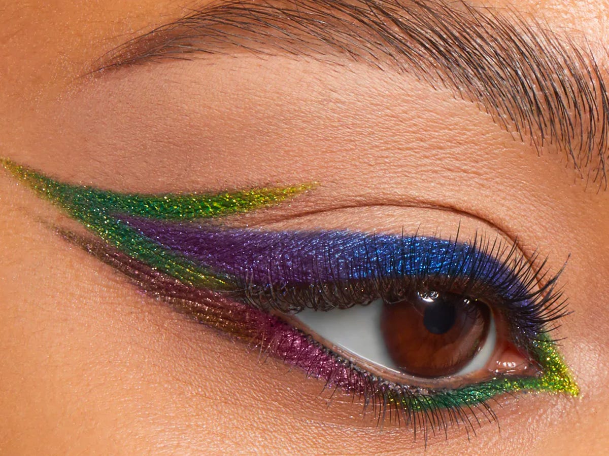 A closeup of a person's eye with a duochrome eyeliner makeup look in several shades.