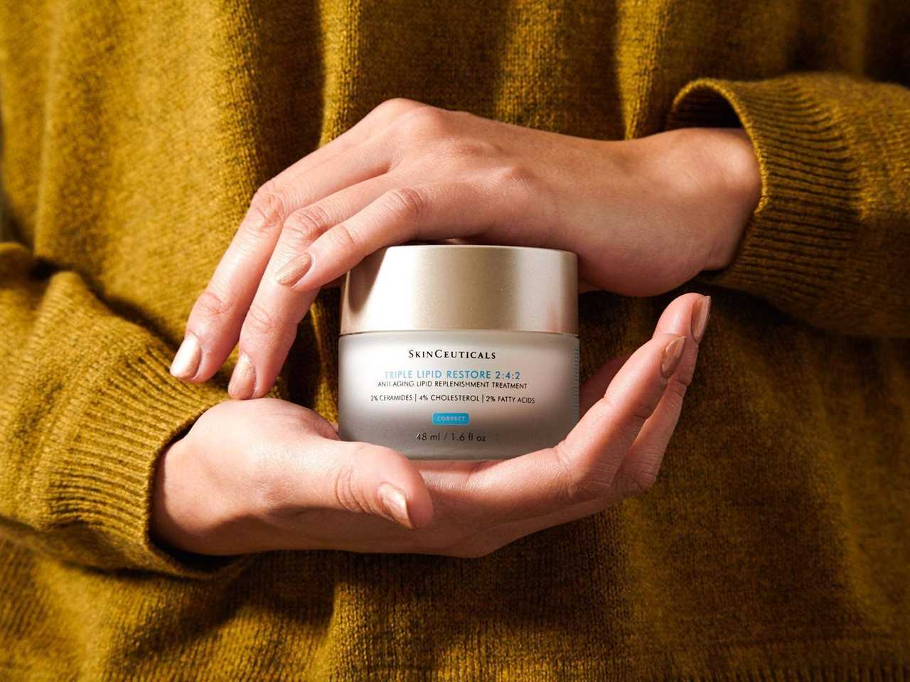 Person holding a jar of SkinCeuticals Triple Lipid Restore in their hands.
