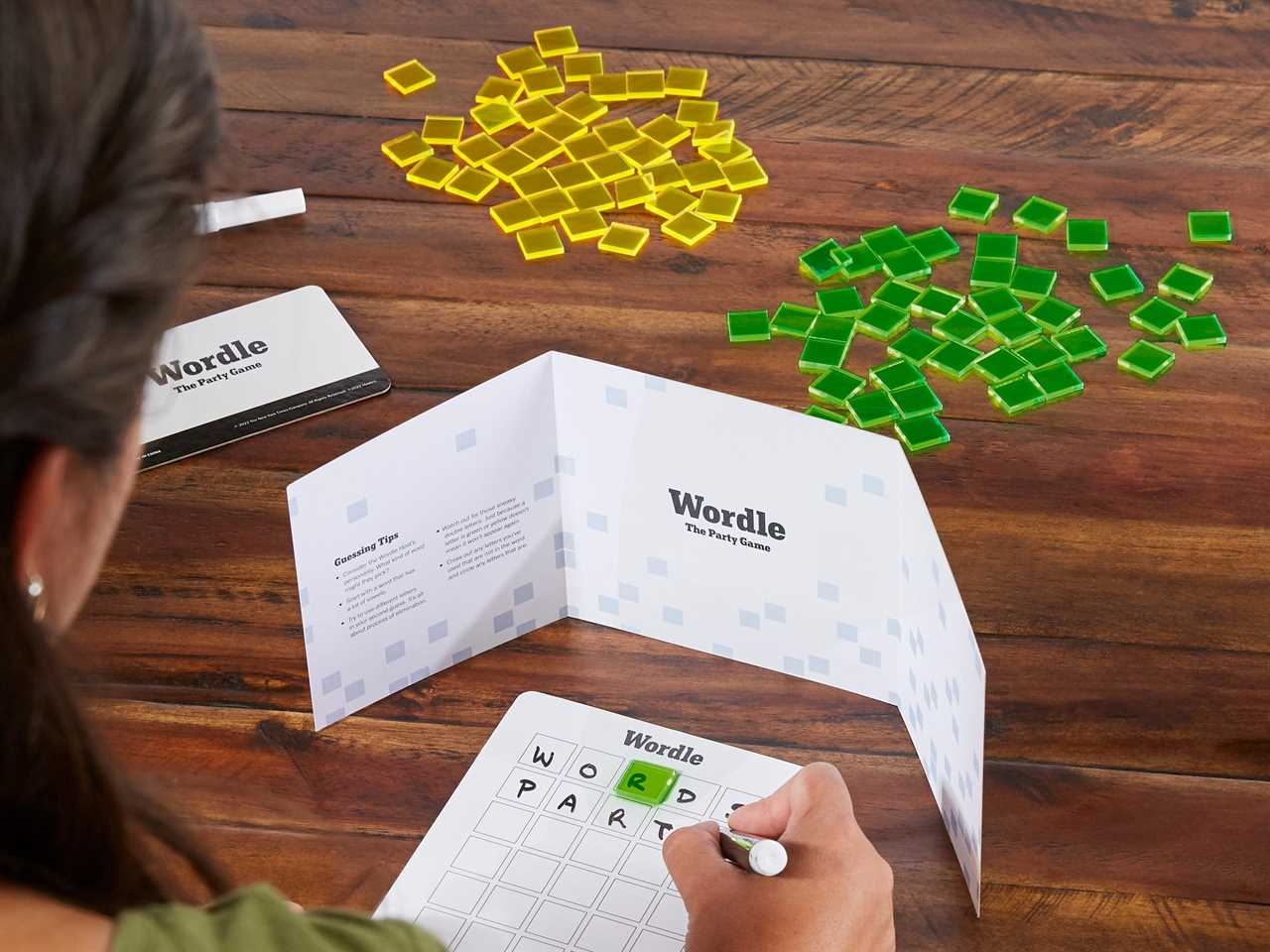 A person plays Wordle: The Party Game, a new board game.