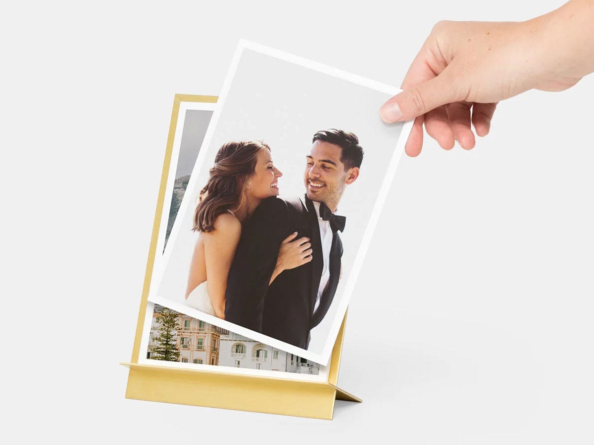 Hand holding a photo of a bride and groom