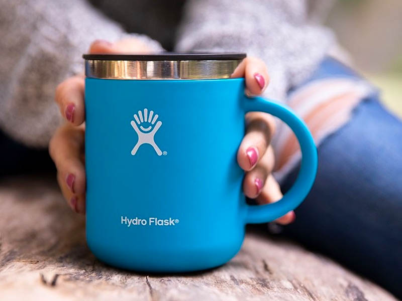 Person holding a Hydro Flask insulated mug.