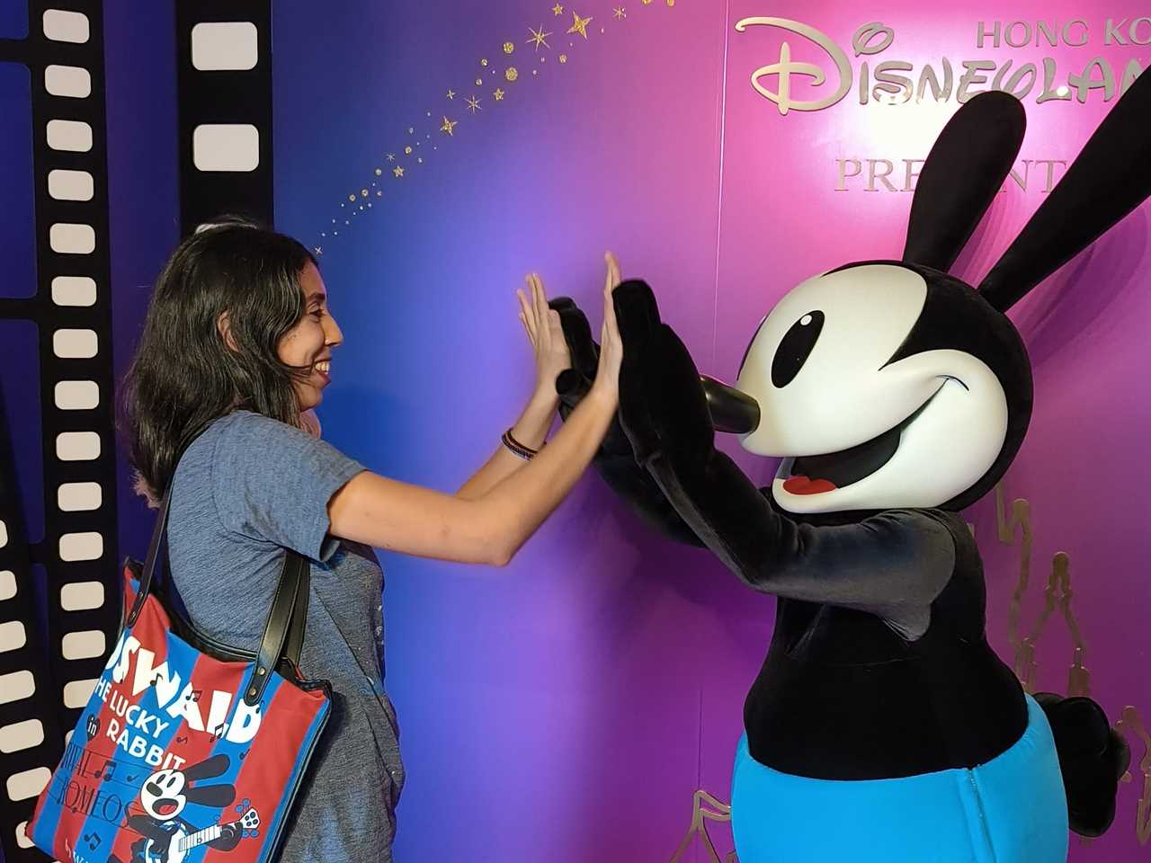 Woman high fiving Mickey Mouse at Disneyland Hong KOng