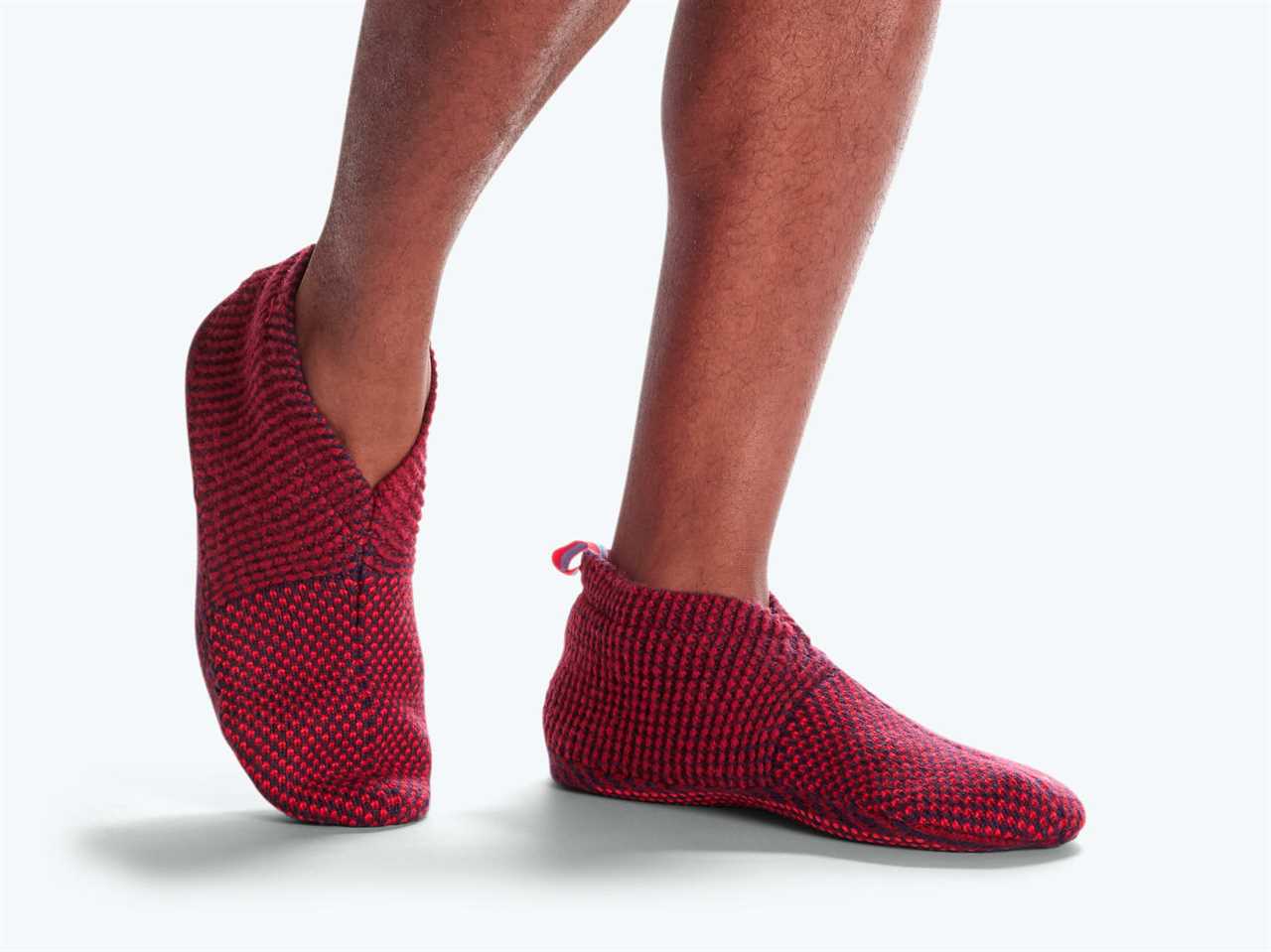 A pair of sock slippers shown on a person's feet.