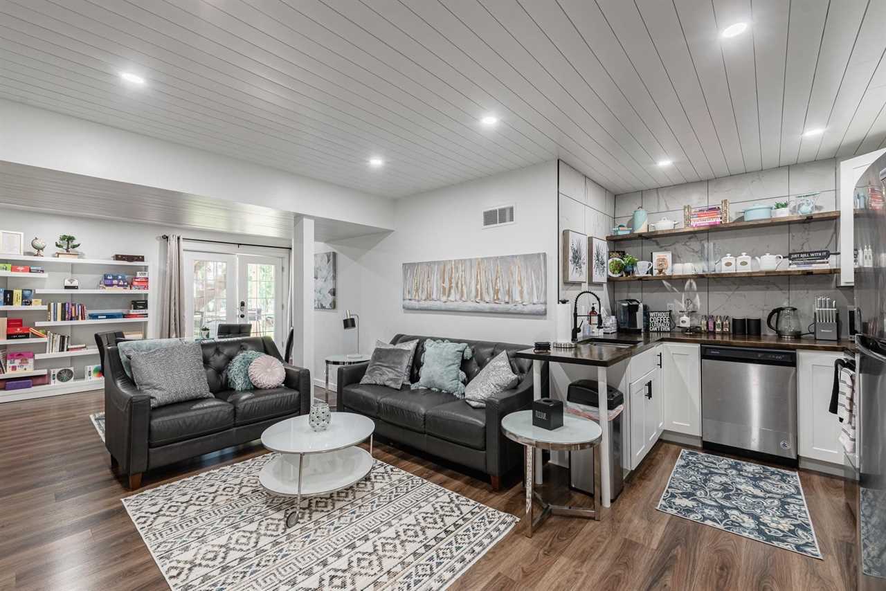 A basement apartment with modern gray finishes and two gray couches.