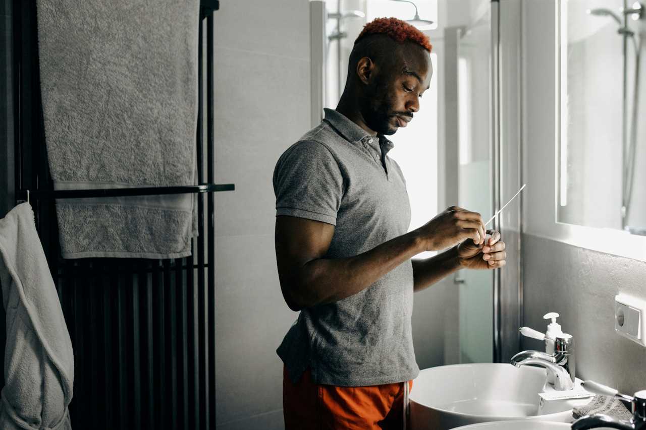 man doing covid test swab in his bathroom