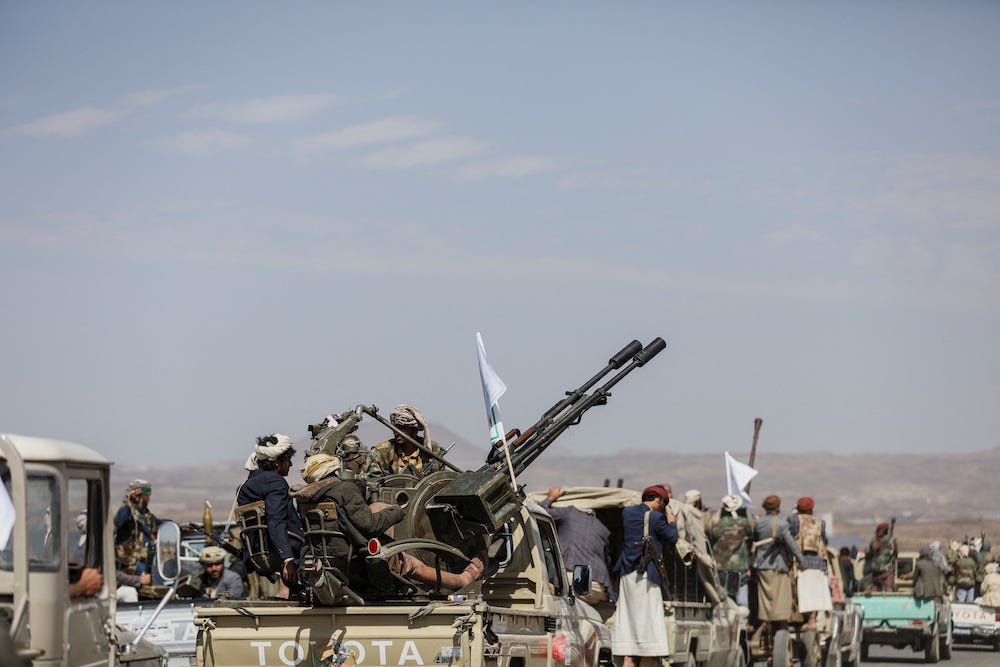 Houthi tribesmen gather around military vehicles to show defiance after U.S. and UK air strikes on Houthi positions near Sanaa, Yemen February 4, 2024