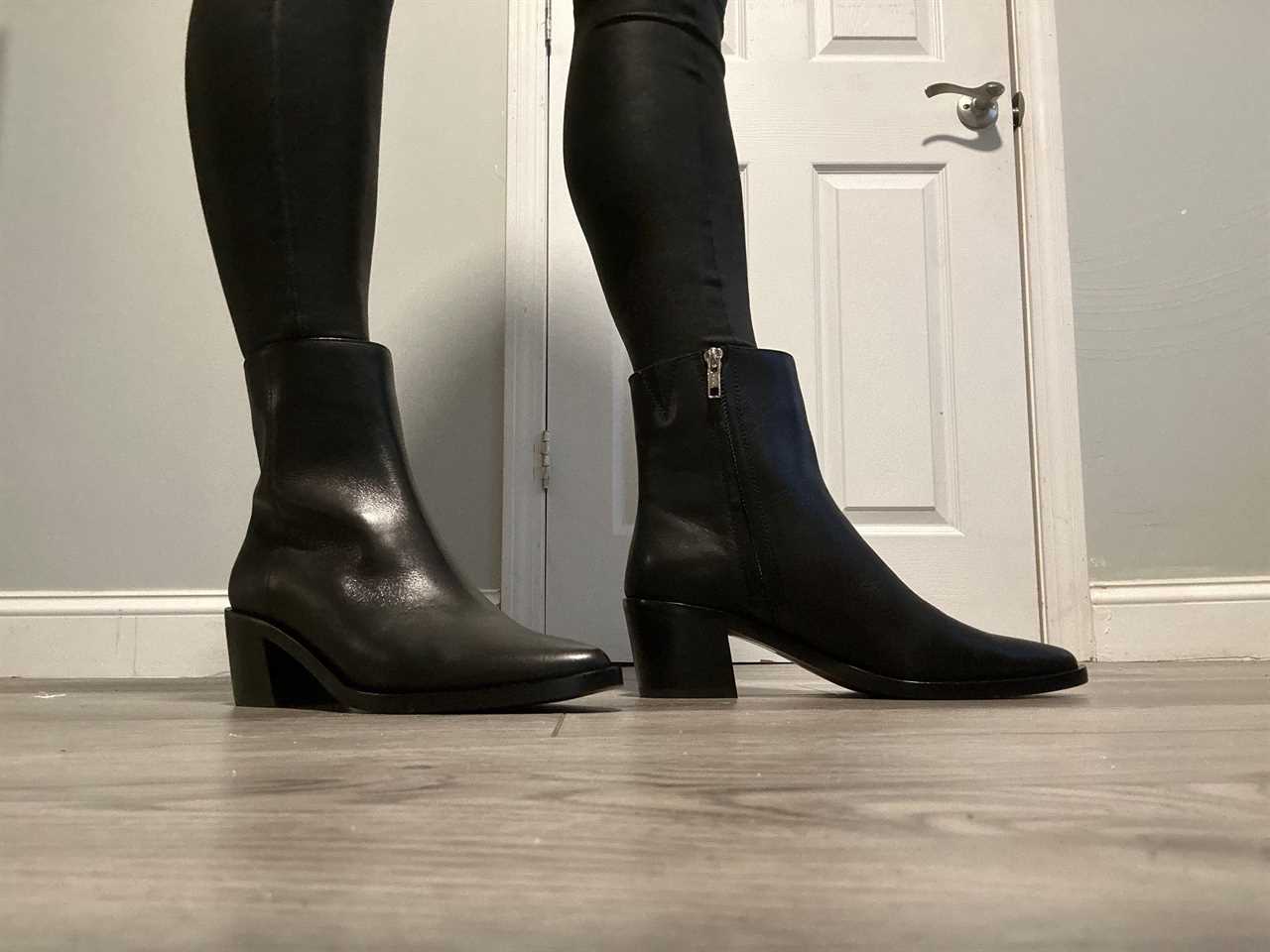 Person wearing a black pair of The Darcy Ankle Boots.