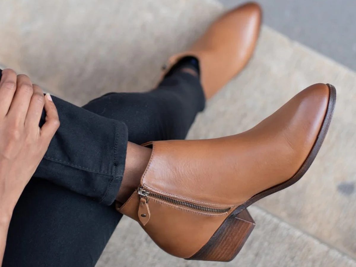 A person with their legs crossed wearing Thursday Boot Co.'s Downtown boots.