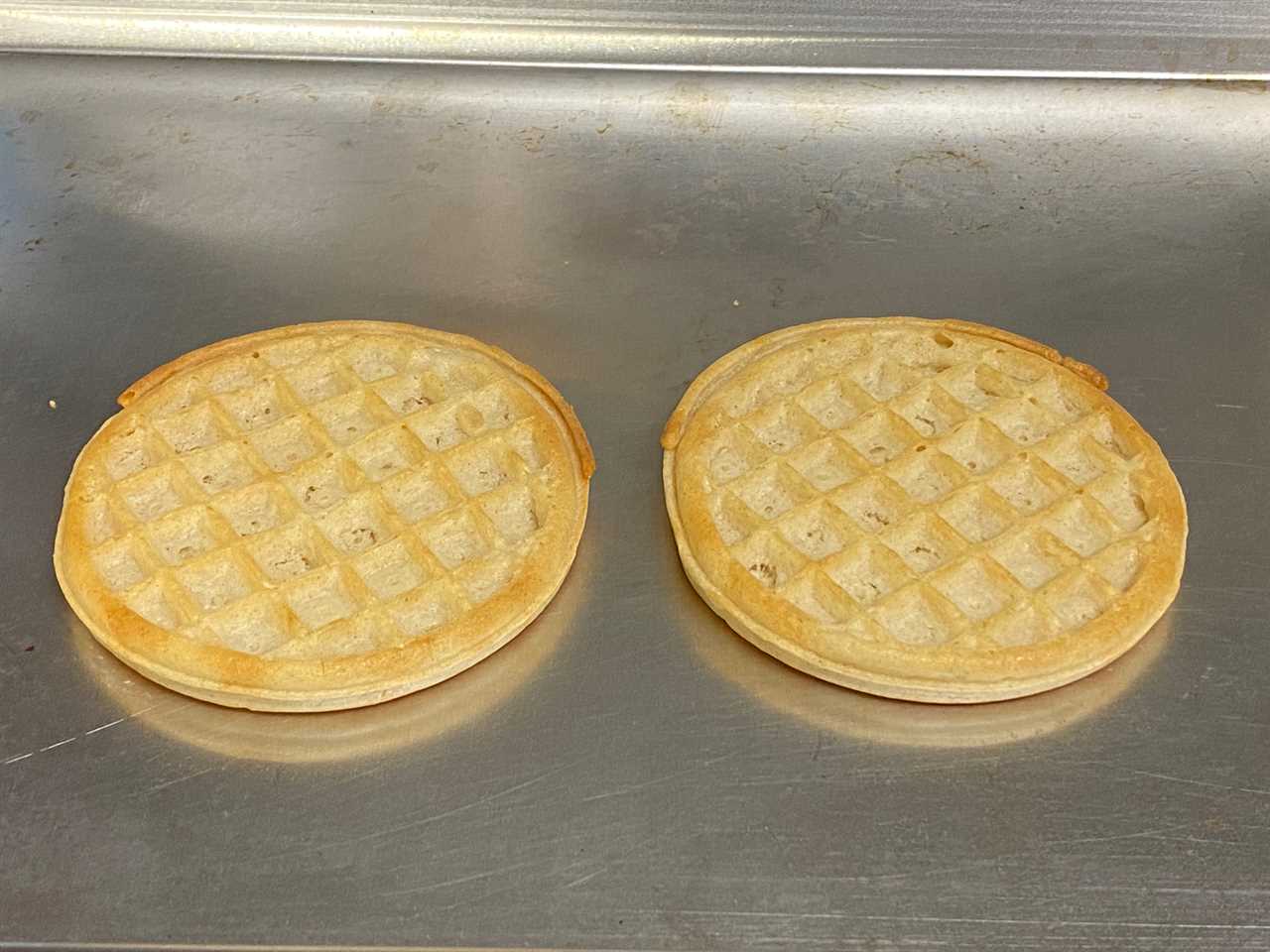 two frozen waffles on a metal surface