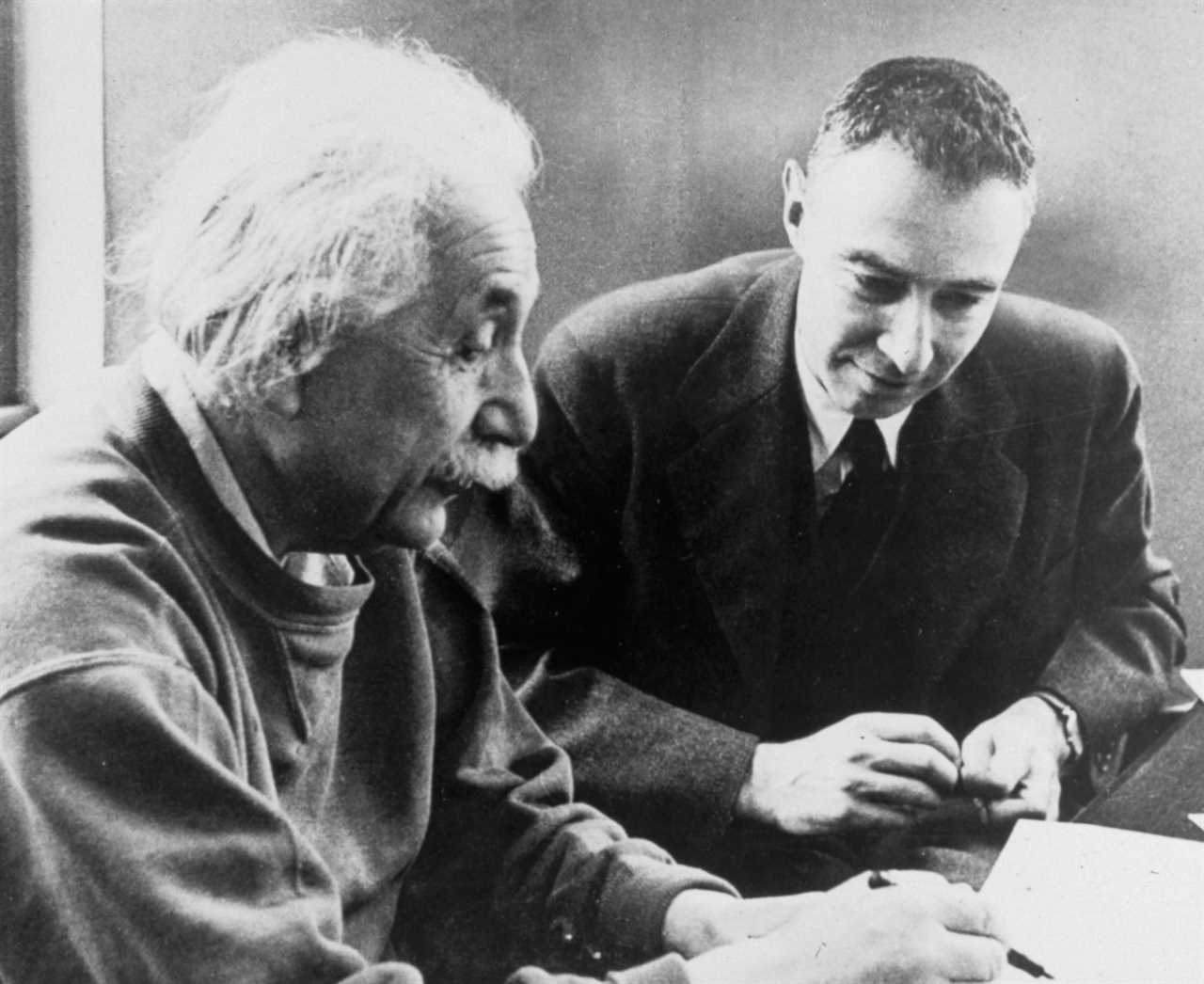 J. Robert Oppenheimer working with Albert Einstein.